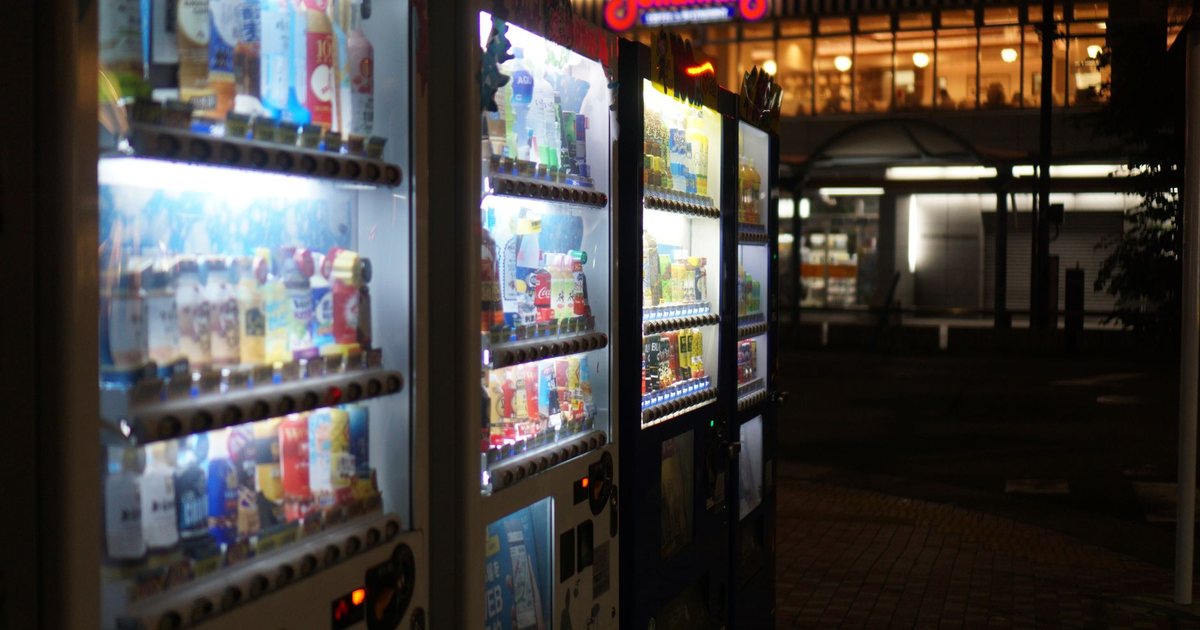 A row of lit vending machines on a street at night