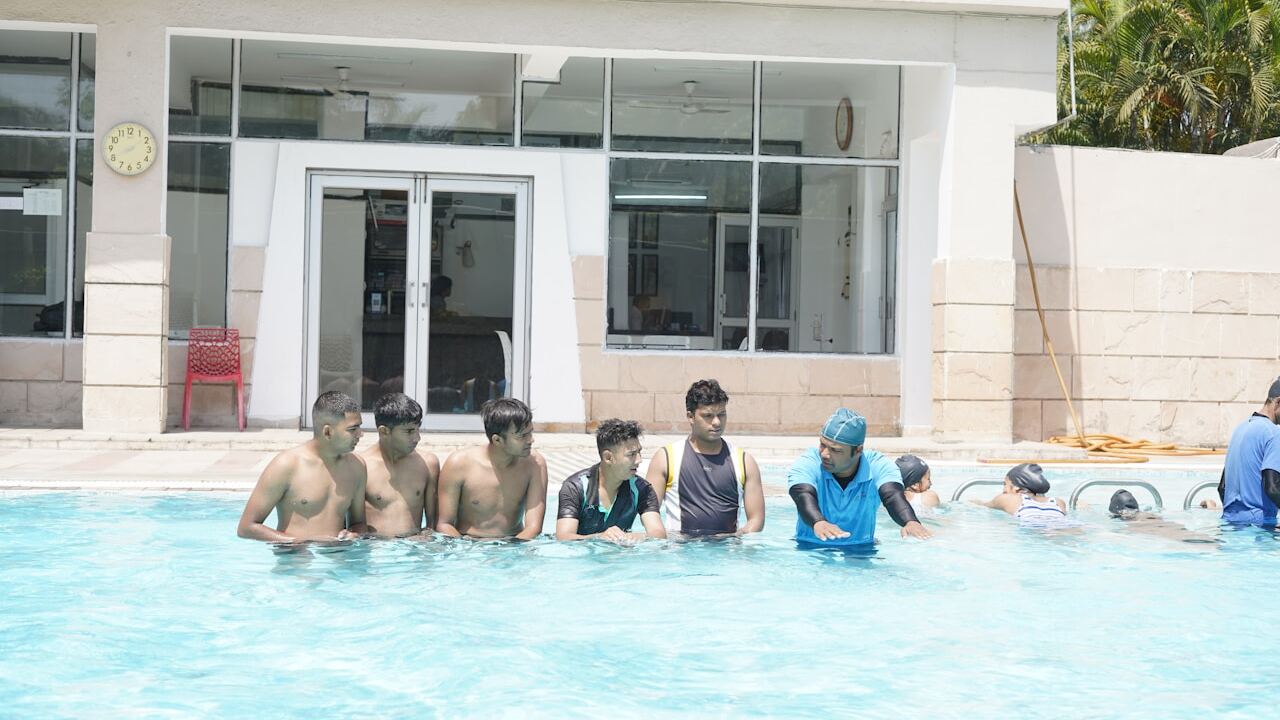 People swimming in a public swimming pool on a summer day